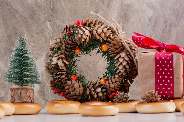 Ghirlanda natalizia di pigne con biscotti e piccola confezione regalo. Foto di alta qualità