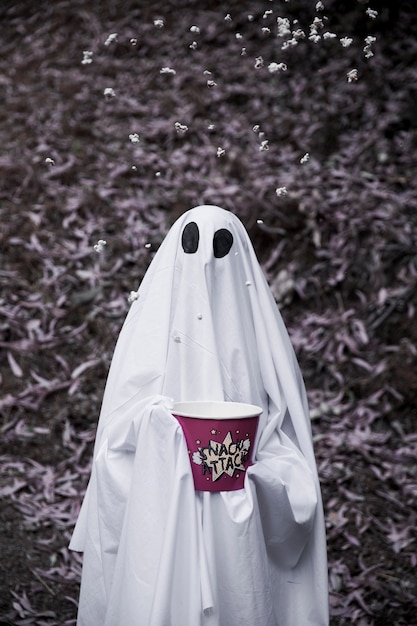 Ghost in possesso di scatola di popcorn con popcorn in aria