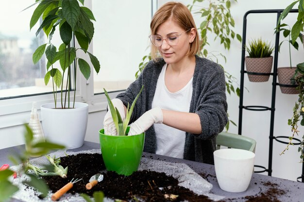 Giardinaggio della donna del colpo medio al chiuso