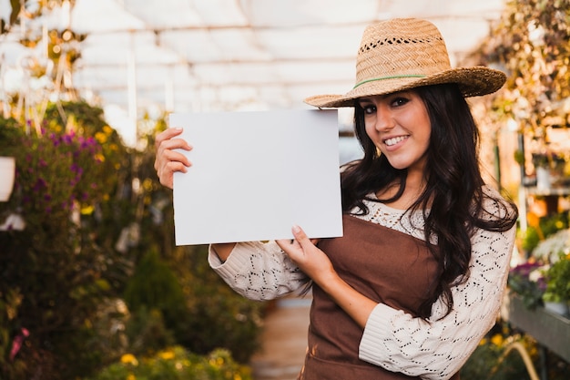 Giardiniere sorridente con foglio di carta