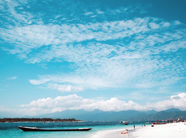 GILI TRAWANGAN INDONESIA 4 LUGLIO 2017 Costa di Gili TRAWANGAN Bella vista sull'oceano blu e sullo sfondo del cielo La gente prende il sole