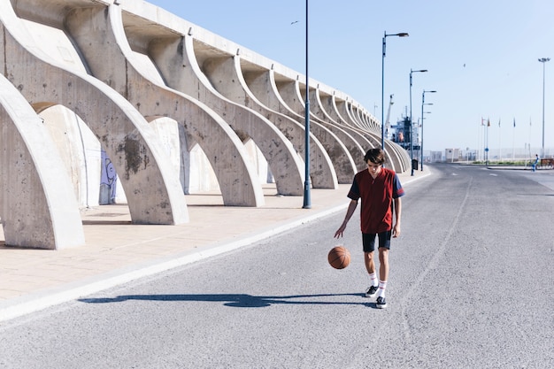 Giocatore che pratica pallacanestro sulla strada in città