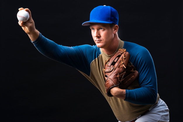 Giocatore di baseball che posa con il guanto e la palla