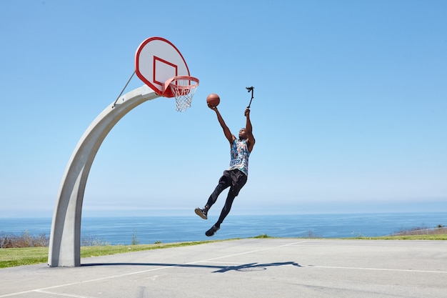 Giocatore di basket che schiaccia con una fotocamera selfie