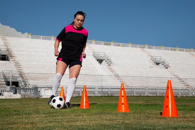 Giocatore di football americano della donna del colpo pieno sul campo