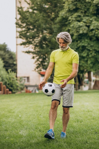 Giocatore di football americano di mezza età con pallone da calcio