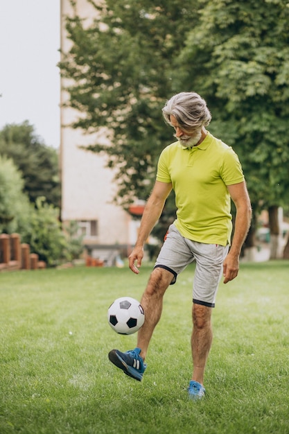 Giocatore di football americano di mezza età con pallone da calcio