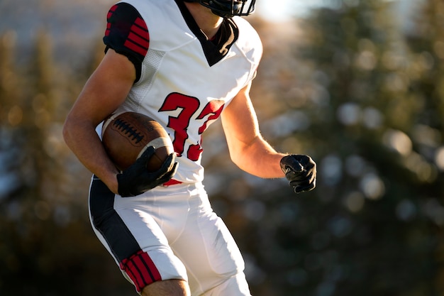 Giocatore di football americano maschio in formazione uniforme sul campo