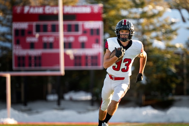 Giocatore di football americano maschio in formazione uniforme sul campo