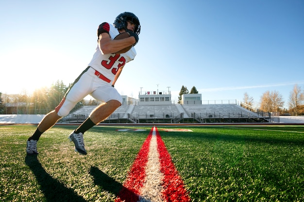 Giocatore di football americano maschio in formazione uniforme sul campo