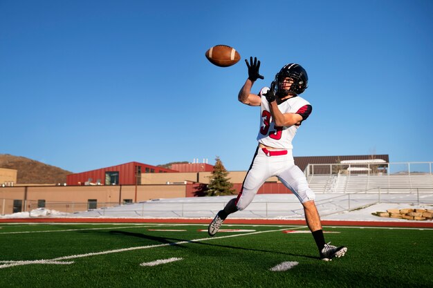 Giocatore di football americano maschio in uniforme sul campo