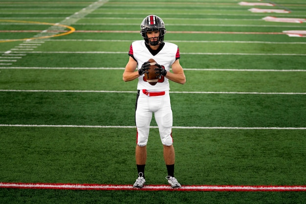 Giocatore di football americano maschio in uniforme sul campo