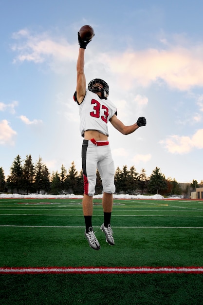 Giocatore di football americano maschio in uniforme sul campo