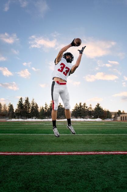 Giocatore di football americano maschio in uniforme sul campo