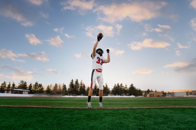 Giocatore di football americano maschio in uniforme sul campo