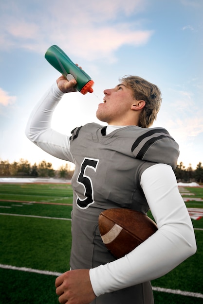 Giocatore di football americano maschio in uniforme sul campo