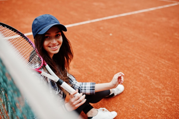 Giocatore di giovane ragazza sportiva con racchetta da tennis sul campo da tennis