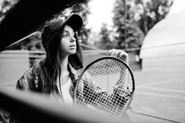 Giocatore di giovane ragazza sportiva con racchetta da tennis sul campo da tennis