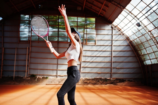 Giocatore di giovane ragazza sportiva con racchetta da tennis sul campo da tennis