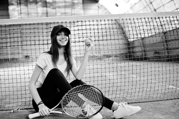 Giocatore di giovane ragazza sportiva con racchetta da tennis sul campo da tennis