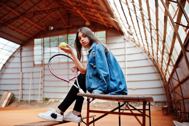 Giocatore di giovane ragazza sportiva con racchetta da tennis sul campo da tennis