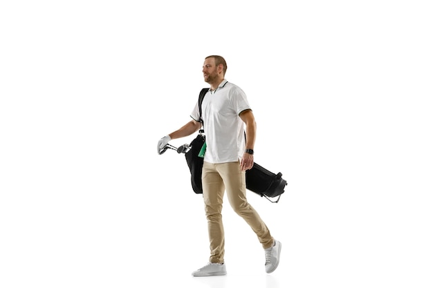 Giocatore di golf in una camicia bianca che fa un'oscillazione isolata sulla parete bianca con copyspace. Giocatore professionista che pratica con emozioni luminose ed espressione facciale. Concetto di sport.