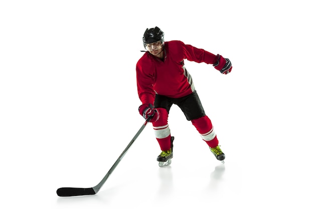 Giocatore di hockey maschio con il bastone sul campo da ghiaccio e sfondo bianco.