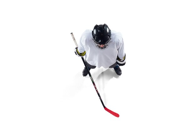 Giocatore di hockey maschio irriconoscibile con il bastone sul campo da ghiaccio e bianco