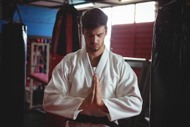 Giocatore di karate in posa di preghiera