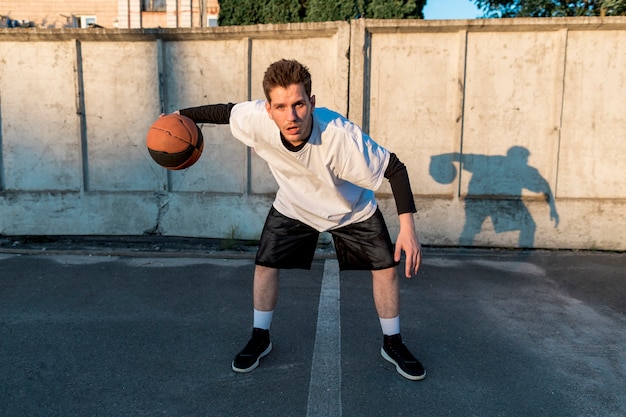 Giocatore di pallacanestro di vista frontale sulla corte urbana