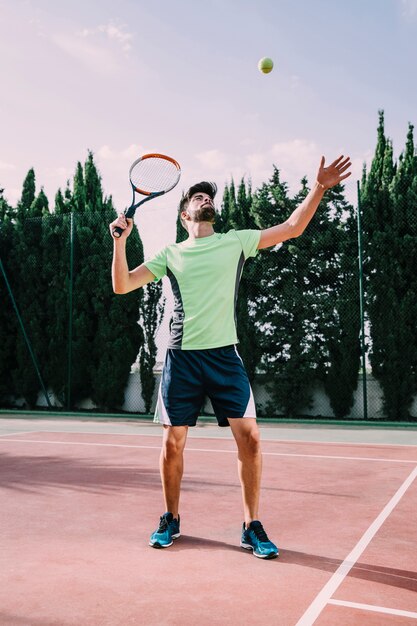 Giocatore di tennis in t-shirt verde che serve