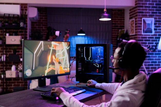 Giocatore maschio che gioca a una competizione di videogiochi online alla stazione del computer, godendosi il gioco multiplayer del torneo di eSport dal vivo. Campionato di gioco in streaming per giovani come attività per il tempo libero.