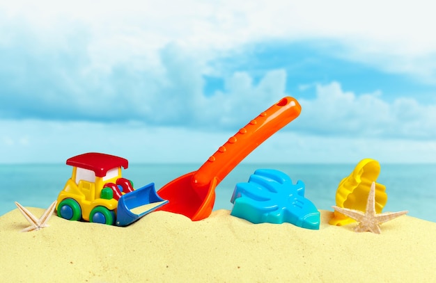 Giocattoli di plastica per bambini sulla spiaggia di sabbia