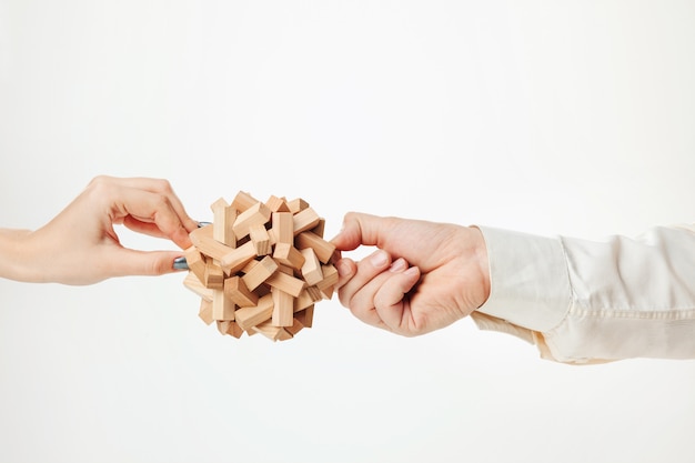 giocattolo puzzle di legno nelle mani isolato su bianco