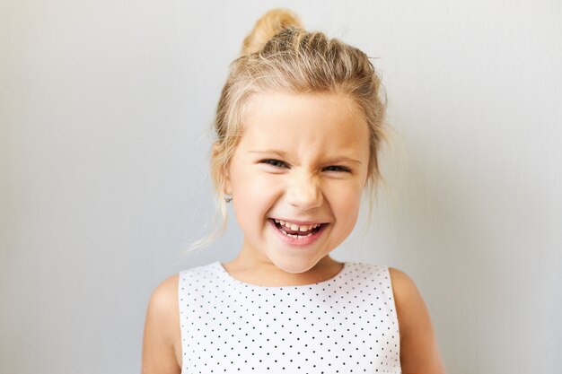 Gioia, emozioni positive e concetto di infanzia felice. Bella adorabile bambina che esclama eccitata, felicissima perché sta andando al parco di divertimenti, al cinema o a fare shopping, ridendo ad alta voce