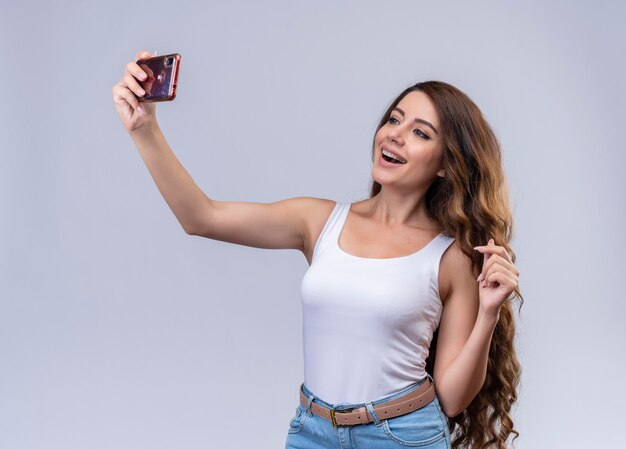 Gioiosa giovane bella ragazza prendendo selfie