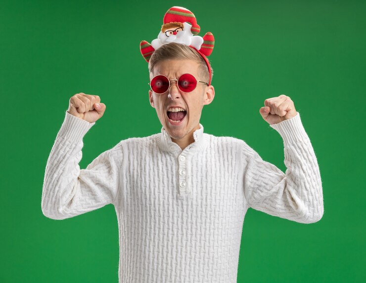 Foto gratuito gioioso giovane bel ragazzo che indossa la fascia di babbo natale con gli occhiali che fa il gesto di sì con gli occhi chiusi isolati sulla parete verde