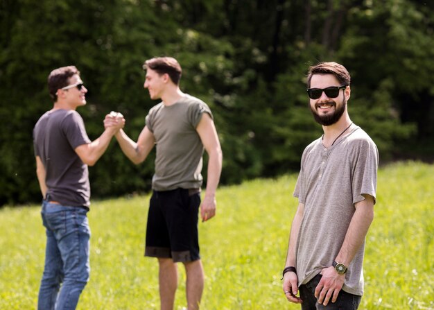 Gioioso giovane in piedi sul picnic con gli amici