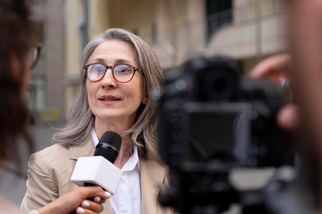 Giornalista che fa un'intervista accanto al suo cameraman