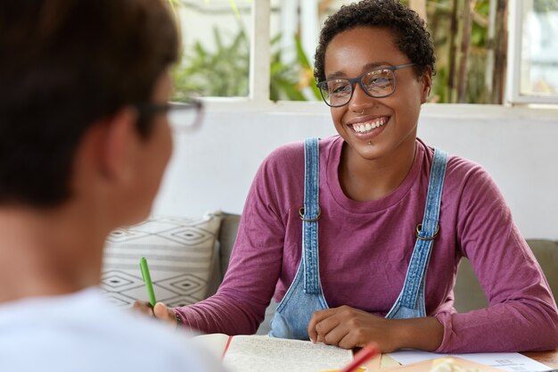 Giornalista femminile nero giovane positivo in spettacoli