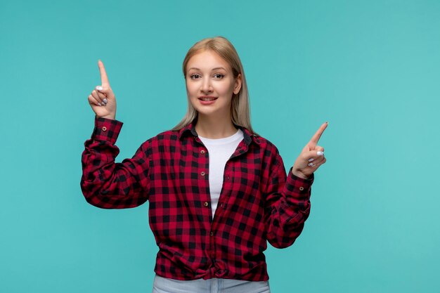 Giornata internazionale degli studenti giovane ragazza carina in camicia rossa a quadri sorridente con le dita in aria