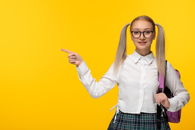 Giornata mondiale del libro sorridente ragazza carina con code di cavallo in uniforme