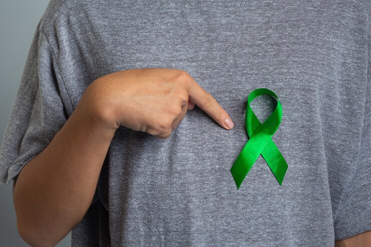 Foto gratuito giornata mondiale della salute mentale. mano che punta al nastro verde