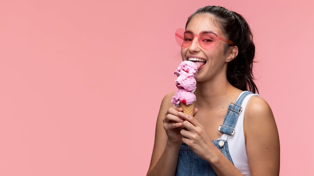 Giovane adolescente con gli occhiali da sole che mangia un gelato