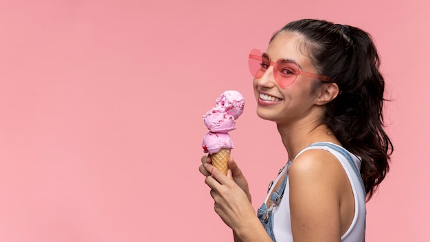 Giovane adolescente con gli occhiali da sole che mangia un gelato