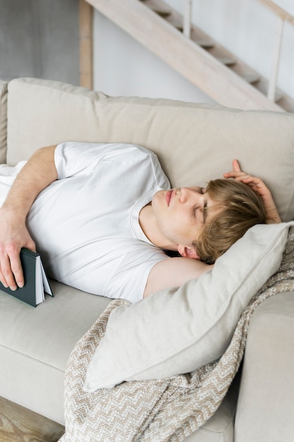 Giovane adulto che dorme durante la lettura