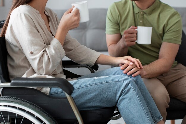 Giovane adulto che mangia caffè con un amico disabile