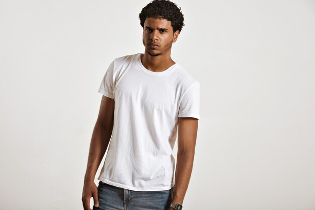 Giovane afroamericano sexy sembrante ansioso in maglietta senza maniche bianca in bianco