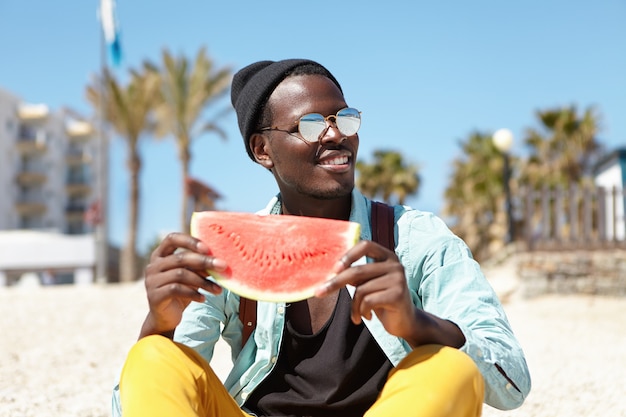 Giovane alla moda in spiaggia