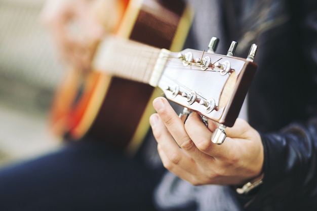 Giovane artista di strada attraente con la sua chitarra